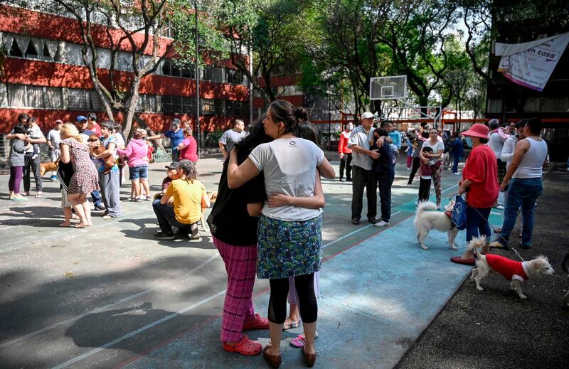 People remain outside buildings in Mexico City during a quake .    AFP