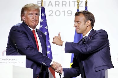 epa07795439 French President Emmanuel Macron (R) and US President Donald J. Trump (L) shake hands and pose as they hold a press conference on the closing day of the G7 summit in Biarritz, France, 26 August 2019.  EPA/IAN LANGSDON