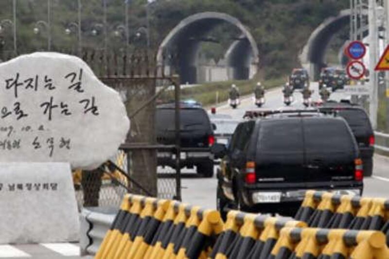 South Korean ex President Roh Moo-Hyun's procession of cars passes by the memorial stone monument of the 2007 South-North Korean summit placed in front of the Southern Gates of the Demilitarized Zone (DMZ) in Paju on October 3, 2007.