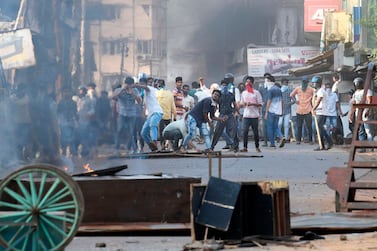 Protesters throw stones toward police during demonstrations in Mangalore on Thursday. AFP