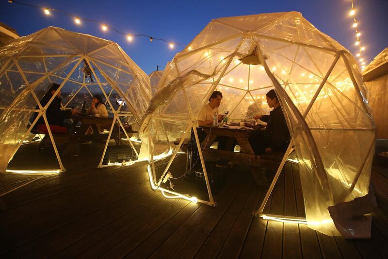 People enjoy outdoor dining at plastic bubbles, observing social distancing against the spread of the coronavirus at a restaurant near the Han River in Seoul, South Korea. AP Photo