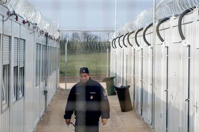 FILE - In this Thursday, April 6, 2017 file photo a Hungarian police officer patrols the enlarged transit zone set up for migrants at the Hungary's southern border with Serbia near Tompa, 169 kms southeast of Budapest, Hungary. Hungary's government says it is shutting down the transit zones on its southern border with Serbia where asylum-seekers are being kept while their asylum requests are decided. (Sandor Ujvari/MTI via AP, file)