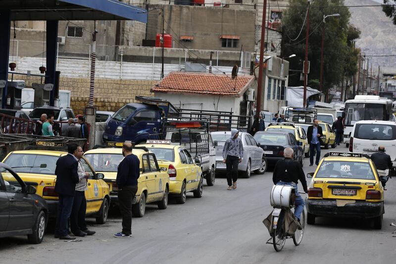 Drivers queue for gasoline in front of a petrol station in the Syrian capital Damascus.  Syria adopted new measures yesterday to curb fuel shortages President Bashar al-Assad's government has blamed on strangling Western sanctions on the war-torn country. AFP
