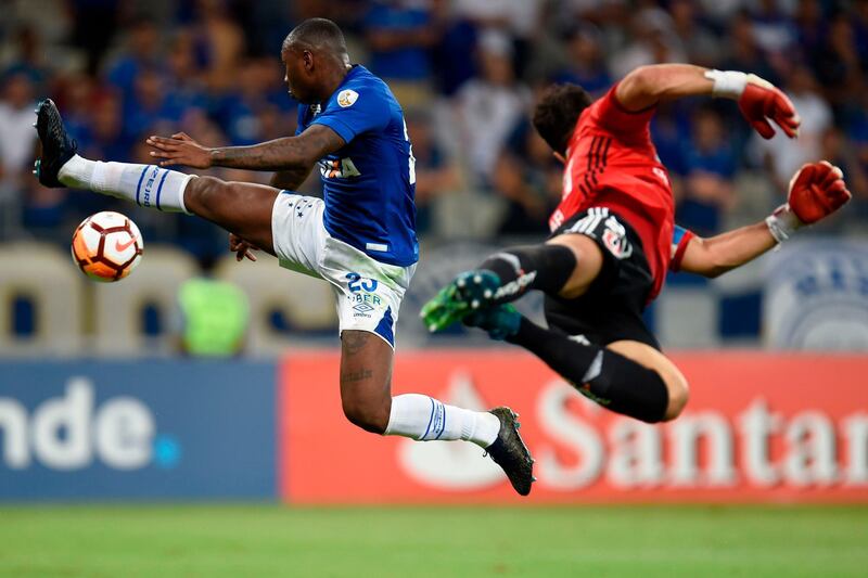 Sassa of Brazil's Cruzeiro and goalkeeper Johnny Herrera of Chile's Universidad de Chile jump in the air for the ball during their Copa Libertadores football match at the Mineirao stadium, in Belo Horizonte, Brazil. Douglas Magno / AFP Photo