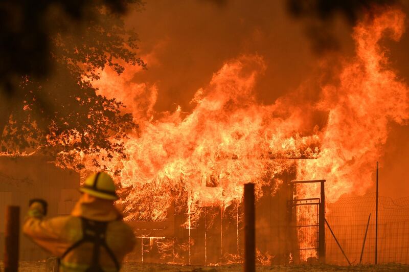 A firefighter watches as a building burns during the Mendocino Complex fire in Lakeport, California.  AFP PHOTO / JOSH EDELSON