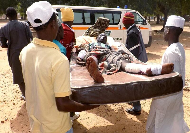 Relatives carry a man injured in a suicide blast in north-east Nigerian town of Potiskum on January 12, 2015. Aminu Abubakar / AFP