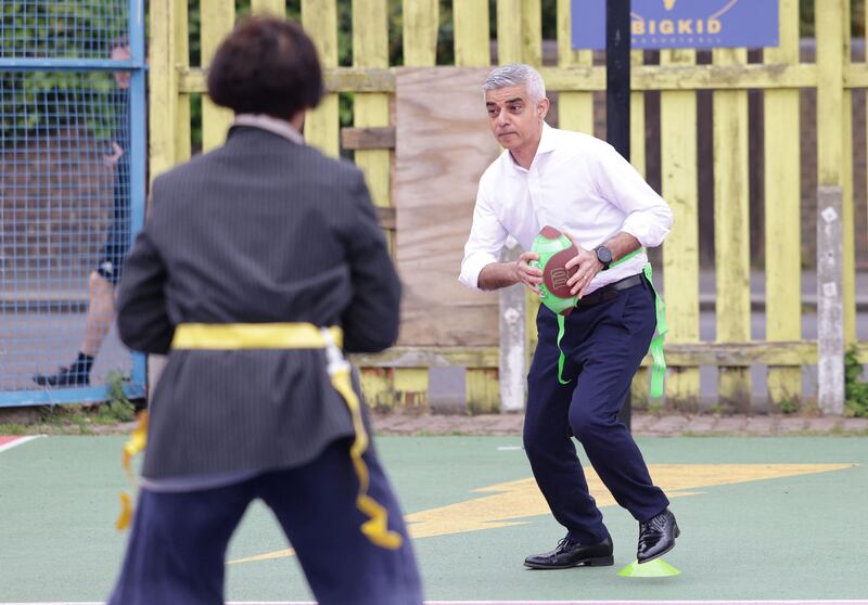 Mr Khan plays flag football on a visit to the BIGKID Foundation in Lambeth. Reuters