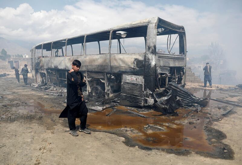 A boy walks past a burnt bus after an overnight fire. Reuters