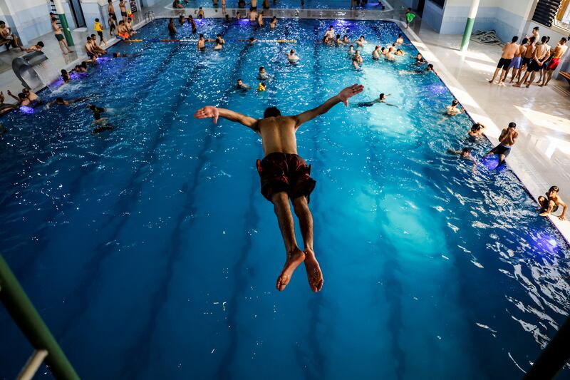 An Iraqi youth dives into a swimming pool to cool off, as temperature rises in Mosul. Reuters