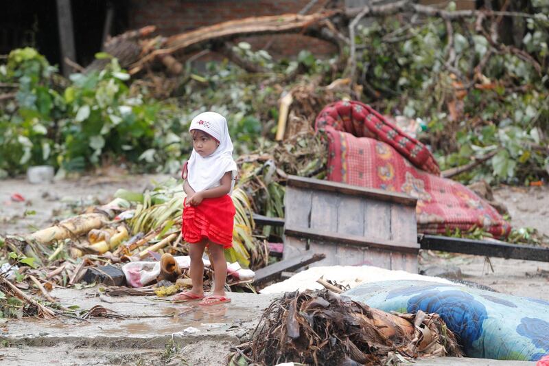 A girl stands among debris in Tanjung Lesung. EPA