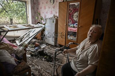 An eldery woman sits inside her damaged house after a missile strike in the city of Soledar, in the eastern Ukrainian region of Donbas. AFP