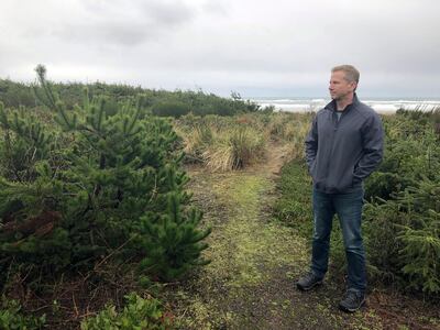 Jeff Bryner gazes, Wednesday, Jan. 8, 2020, at the lot that a Facebook subsidiary bought to convert it into a landing site for a trans-oceanic cable in Tierra Del Mar, Ore. (AP Photo/Andrew Selsky)