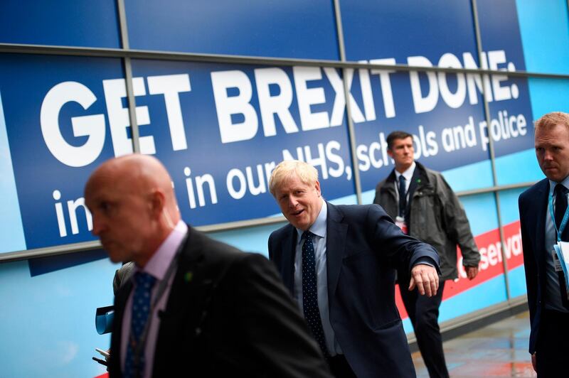 Britain's Prime Minister Boris Johnson (C) walks outside the Manchester Central convention complex in Manchester, northwest England on September 29, 2019, on the first day of the annual Conservative Party conference. Embattled British Prime Minister Boris Johnson gathered his Conservative party Sunday for what could be its final conference before an election, promising to "get Brexit done". / AFP / Oli SCARFF                          
