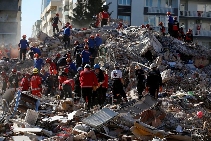 Members of rescue services search in the debris of a collapsed building for survivors in Izmir. AP