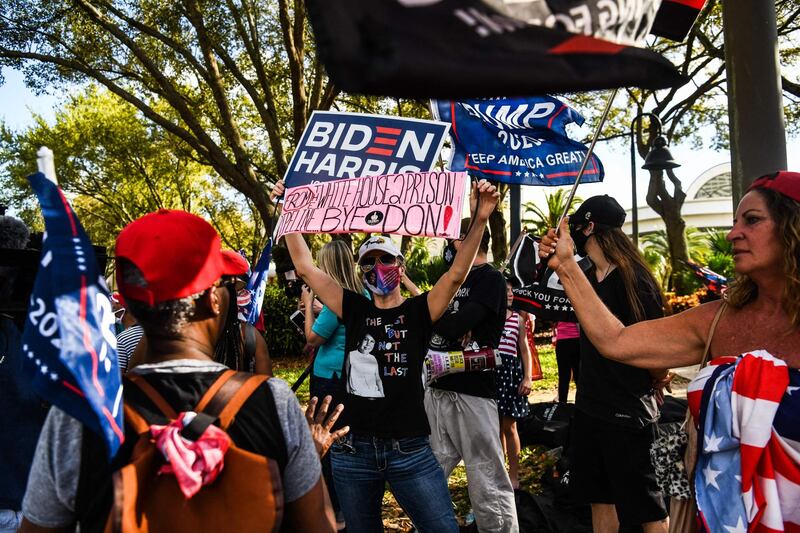 Supporters of US President Joe Biden and his predecessor Donald Trump gather outside the hotel in Orlando that hosted the conference this year. AFP