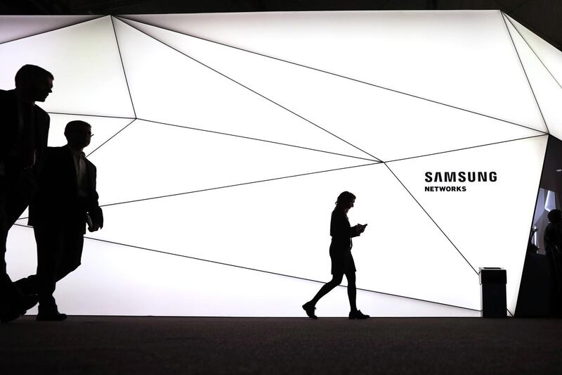 Silhouettes of Mobile World Congress attendees seen walking by the Samsung Electronics Co pavilion during the opening day of the MWC in Barcelona, Spain. Simon Dawson / Bloomberg