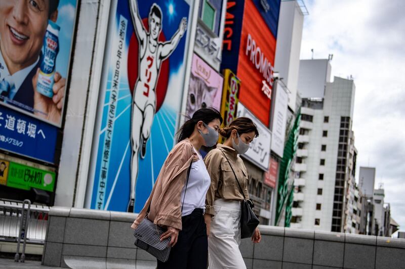 People walk in the Dotonbori area of Osaka on April 16, 2021, as record numbers of new Covid-19 infections were reported in the city in recent days. / AFP / Philip FONG
