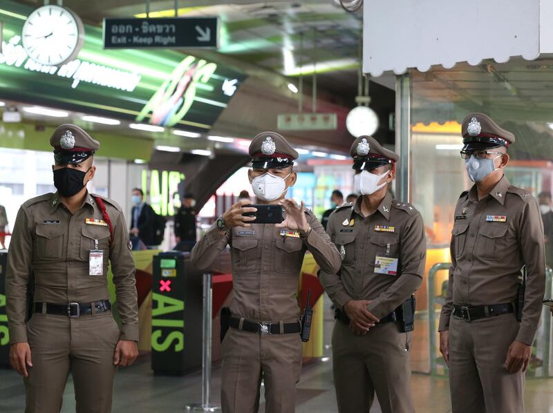 Thai police officers wear protective masks as they stand guard at a skytrain station in Bangkok, Thailand.  EPA