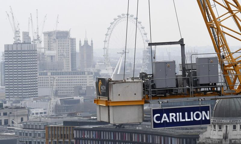 A construction crane showing the branding of British construction company Carillion is photographed on a building site in central London on January 14, 2018, with the skyline of the British capital in the background including the London Eye and the Houses of Parliament.  
The British government is keeping a "very close eye" on construction and outsourcing group Carillion, a senior minister said January 14, 2018, amid reports it could go into administration within days. / AFP PHOTO / Daniel SORABJI