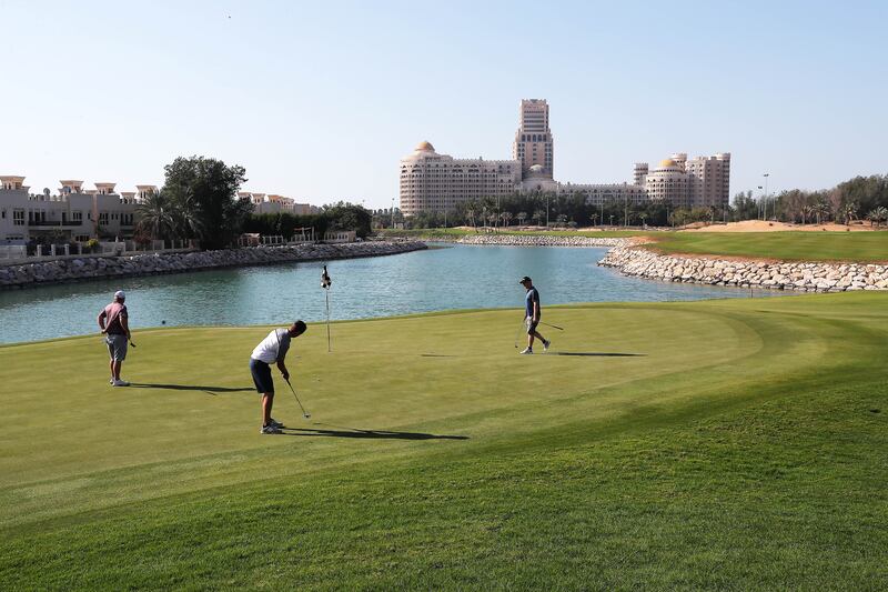 Golfers putt on one of the greens at Al Hamra Golf Club.