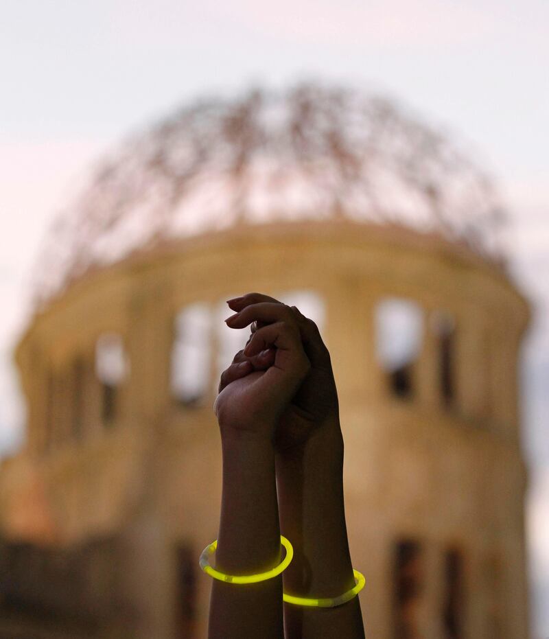 Two women hold hands as they pose for photographers after forming a human chain to surround the gutted Atomic Bomb Dome during an event to commemorate victims of the atomic bombing and demand the halt of nuclear power across Japan, in Hiroshima, western Japan, August 5, 2011. Hiroshima, in the wake of the Fukushima nuclear crisis, will on Saturday commemorate 66 years since the world's first atomic bombing. REUTERS/Kim Kyung-Hoon (JAPAN - Tags: ANNIVERSARY IMAGES OF THE DAY SOCIETY) *** Local Caption ***  HIR705_JAPAN-_0805_11.JPG