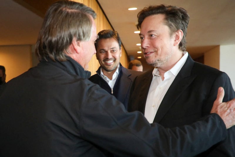 Mr Bolsonaro and Mr Musk greet each other in Sao Paulo. Reuters