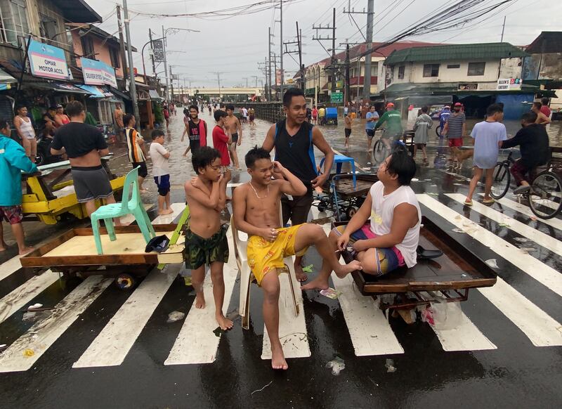 Residents leave their flooded homes in Las Pinas city on makeshift carts.