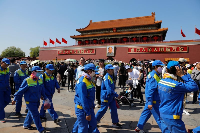 Chinese street cleaners walk in front of the Tiananmen Gate in Beijing, China.  EPA