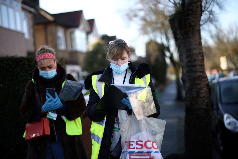 Workers look a list of addresses as they deliver home test kits for residents in Pollards Hill, London. Reuters