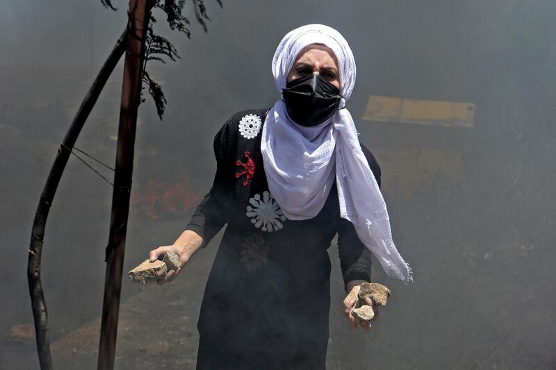 A Palestinian protester collects stones amid clashes with Israeli security forces near the settlement of Beit El and Ramallah in the occupied West Bank. AFP