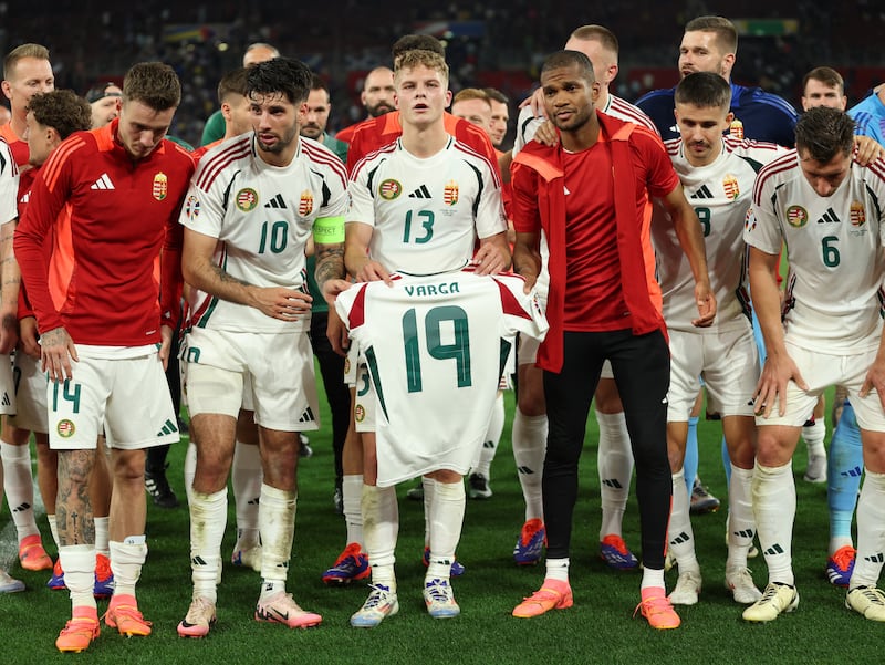 Andras Schafer and the Hungary players hold up the shirt of Barnabas Varga, who was taken to hospital after being injured. Getty Images