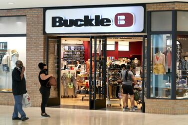 Shoppers wearing protective masks wait in line outside a Buckle store at the Galleria Dallas mall in Dallas, in the US. Restaurants, malls, and stores reopened in Texas on May 1, limited to 25 per cent occupancy. Bloomberg
