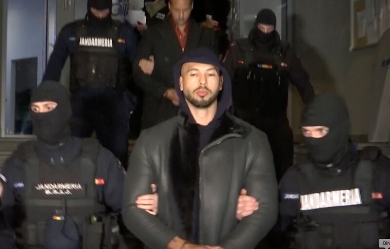 Andrew Tate is led away by Romanian police, in Ilfov, north of Bucharest, Romania. AP