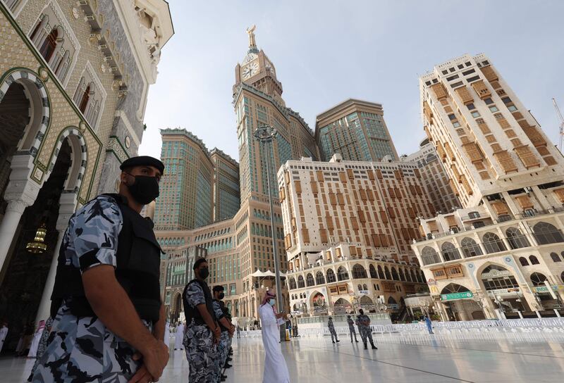 Saudi troops stand guard as the first pilgrims arrive at the Kaaba, Islam's holiest shrine, at the Grand Mosque.