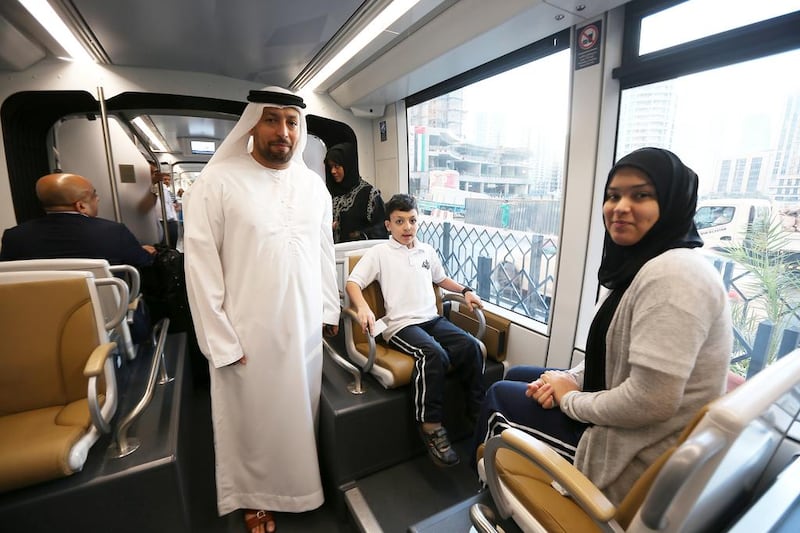 Abu Rashid, left, his daughter Shahd, right, and son Rashid, centre, take a ride on the Dubai Tram on its first day of service. Pawan Singh / The National