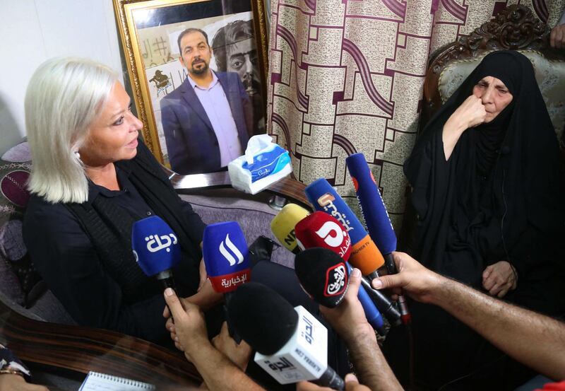 Special Representative of the Secretary-General for the United Nations Assistance Mission for Iraq, Jeanine Hennis-Plasschaert (L), visits the mother of assassinated Iraqi activist Ihab Jawad al-Wazni (image), in her home in the central city of Karbala, on June 24, 2021. Wazni, an Iraqi pro-democracy activists was shot dead on May 9 by men on motorbikes using a silencer in an ambush outside his home in the city of Karbala.   / AFP / Mohammed SAWAF
