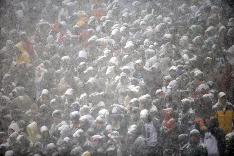 Fans huddle together, covered in snow, in Philadelphia. Matt Rourke / AP