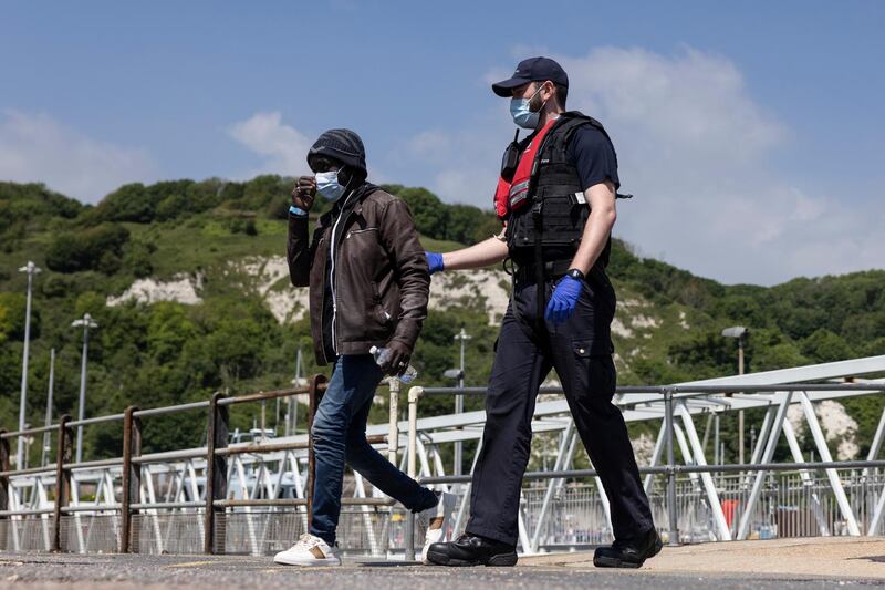 DOVER, ENGLAND - JUNE 24: Border Force officials guide newly arrived migrants to a holding facility after being picked up in a dinghy in the English Channel on June 24, 2021 in Dover, England. More than 5,000 migrants have arrived this year by crossing the English Channel in boats. (Photo by Dan Kitwood/Getty Images)