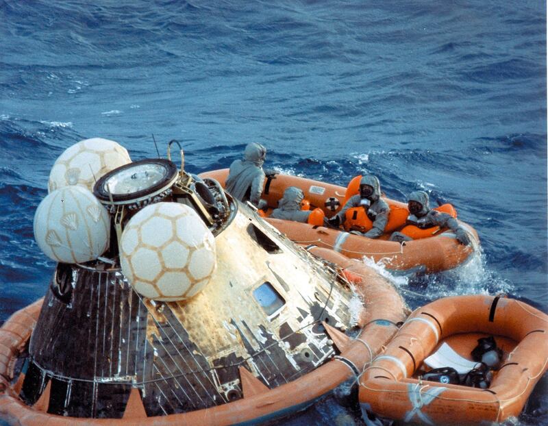 U.S. Navy pararescueman Lieutenant Clancey Hatleberg disinfects Apollo 11 astronauts Neil A. Armstrong, Michael Collins, and Buzz Aldrin, wearing their quarantine suits in the life raft during recovery operations on July 24, 1969 after the successful completion of their lunar landing mission.   AFP PHOTO NASA (Photo by NASA / AFP)