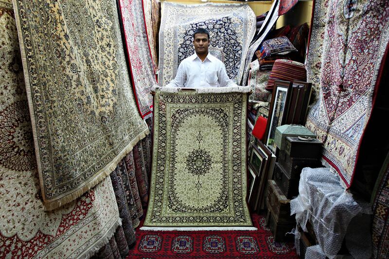 SHARJAH, UNITED ARAB EMIRATES Ð July 27: Mohammed Titu Mizan is from Chittagong in Bangladesh working as a sales person. He is looking after carpet and antique shops at the heritage area in Sharjah. His owner is from Yemen. He came to UAE 6 years back. He is showing one of the costliest carpet in his shop. The cost of this carpet is around 7000 dhs. (Pawan Singh / The National) For News. A Week In Feature