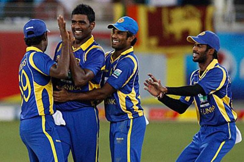 Thisara Perera, second left, celebrates with his Sri Lankan teammates after the wicket of Imran Farhat, the Pakistan opener, during their ODI win in Dubai yesterday.