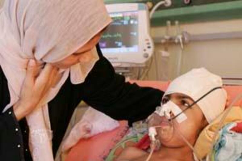 Hiba Mohammed, an eight-year old Iraqi girl,  is comforted by her mother at a hospital in Baghdad, after she was wounded in a suicide bombing attack in Abu Ghraib, in Baghdad, Iraq, Tuesday, March 10, 2009.  A suicide bomber detonated an explosives belt as Iraqi tribal leaders were walking through the market in Abu Ghraib, accompanied by security officials and journalists, killing as many as 33 people, according to the Iraqi military.  (AP Photo/Adil al-Khazali) *** Local Caption ***  BAG106_APTOPIX_Iraq_Suicide_Bombing.jpg