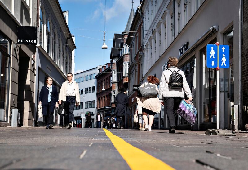 Yellow stripe is painted in the middle of a pedestrian street to help people comply with the social distance guidelines related to the coronavirus disease (COVID-19) situation in Aalborg, Denmark May 4, 2020. Henning Bagger/Ritzau Scanpix/via REUTERS    ATTENTION EDITORS - THIS IMAGE WAS PROVIDED BY A THIRD PARTY. DENMARK OUT. NO COMMERCIAL OR EDITORIAL SALES IN DENMARK.