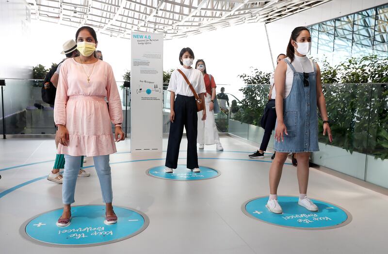 Visitors stand on discs and try to maintain their balance for a steady supply of electricity at the Germany pavilion.