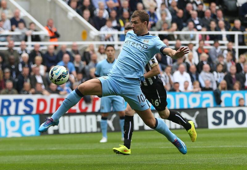 Edin Dzeko, in blue, says his new teammates at Manchester City will need time to settle down. Ian MacNicol / AFP