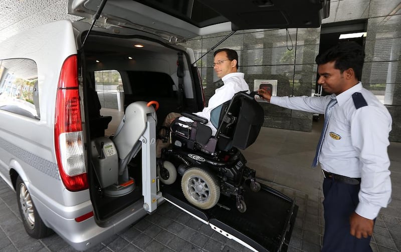 Scott Sankey, a Canadian expatriate, is assisted on to one of the Mercedes Vito Compact taxis in Abu Dhabi. Pawan Singh / The National