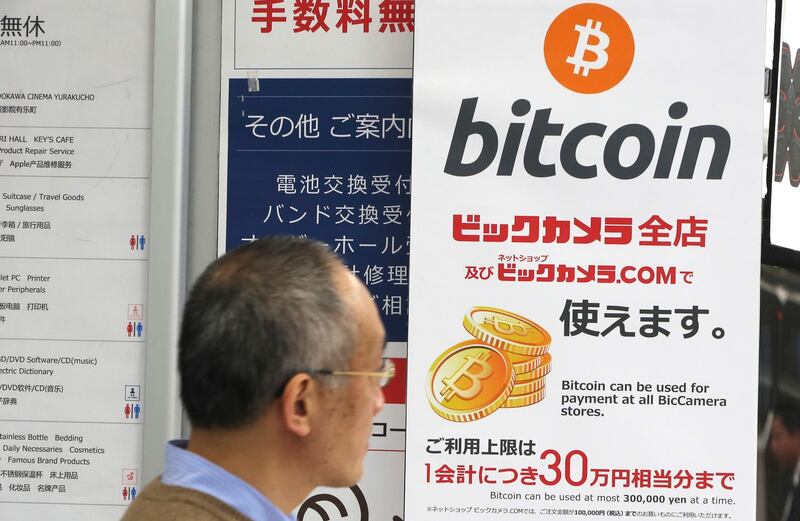 In this Friday, Jan. 19, 2018, photo, a man walks past a poster of bitcoin displayed at a retail store in Tokyo. Blockchain is a decentralized technology that can make transactions safe and secure, but crypto-currency exchanges that trade bitcoins and other virtual currencies that are based on this technology have been hacked because they are not working on secure networks. (AP Photo/Koji Sasahara)