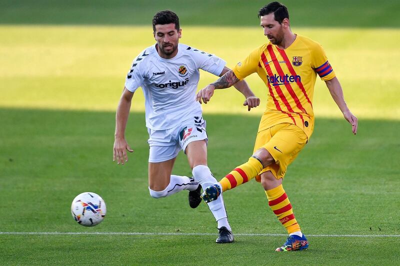 Lionel Messi passes the ball under pressure from Gimnastic defender Javi Bonilla. AFP