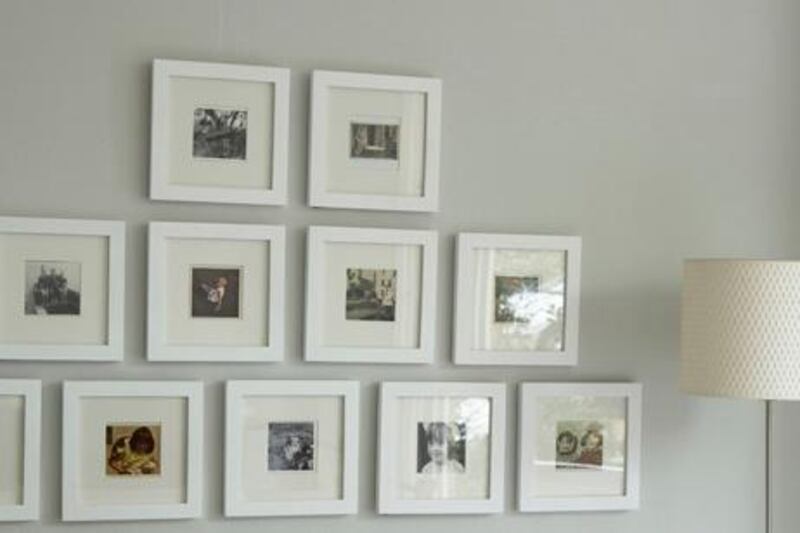 A selection, collection of framed photographs in white square frames. H&G 06/2008 pub orig