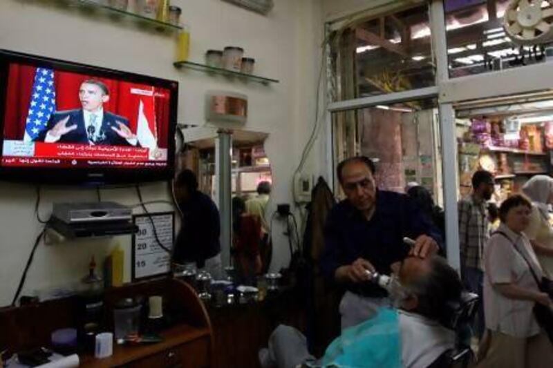 Palestinians at a barber shop in East Jerusalem watch Barack Obama deliver his landmark speech at Cairo University in 2009. Ahmad Gharabli / AFP